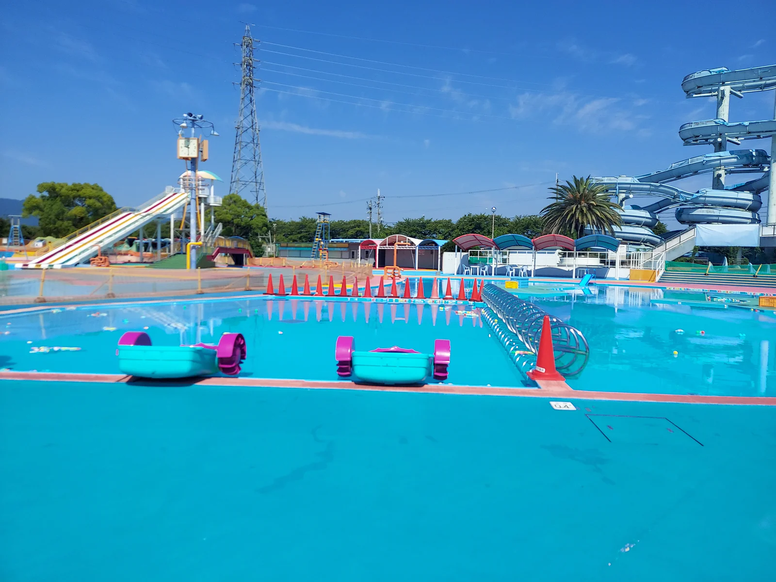 橿原じゃぶじゃぶパークのパドルボートエリア。浅いプールに水色のパドルボートが並び、奥にスライダーが見える